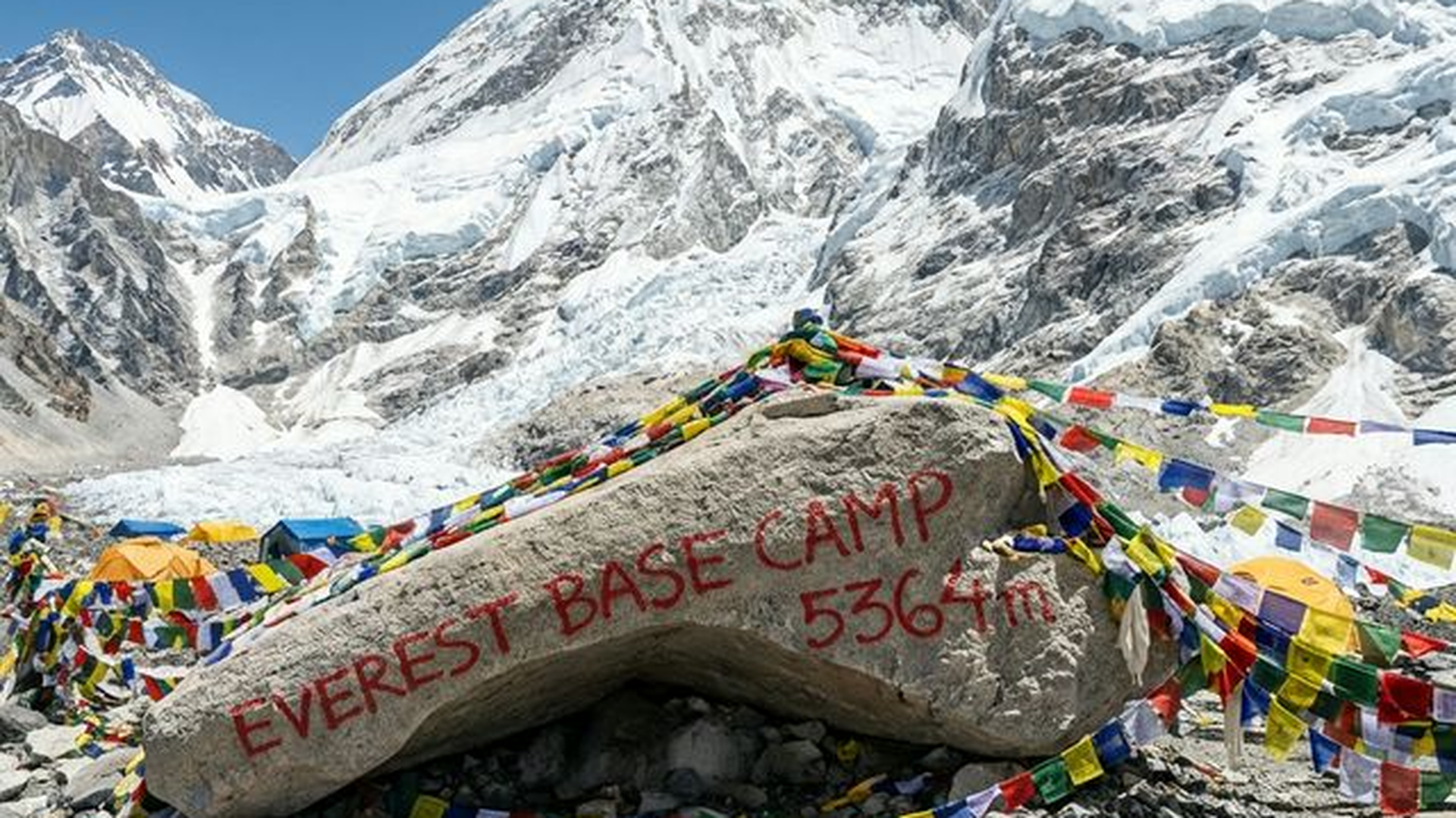Trekker approaching Everest Base Camp with tents