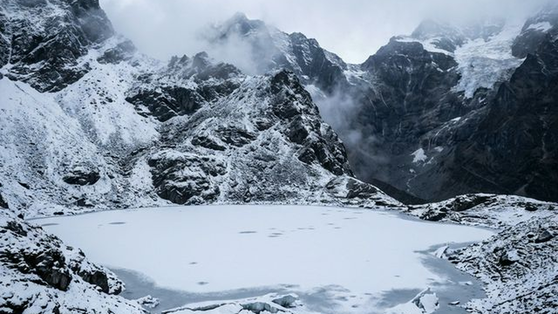 Frozen Roopkund Lake surrounded by snow